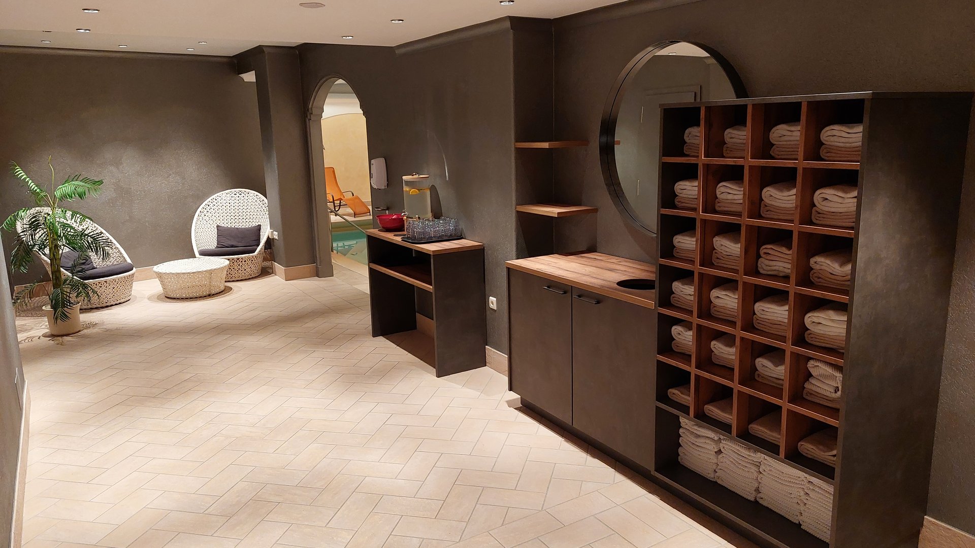 Deine Unterkunft in St. Christina im Grödnertal: Willkommen! Moderner Wellnessbereich mit Handtüchern, Sitzgelegenheiten und Zugang zum Pool