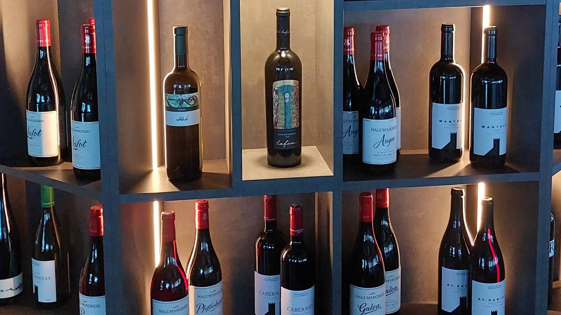 Il nostro hotel a 3 stelle in Val Gardena e la sua cucina Bottiglie di vino in una cantina moderna e illuminata