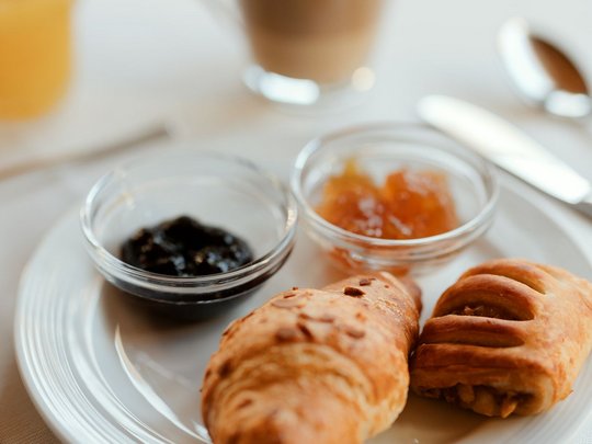 Il nostro hotel a 3 stelle in Val Gardena e la sua cucina Piatto per la colazione con cornetti, marmellata e una tazza di caffè