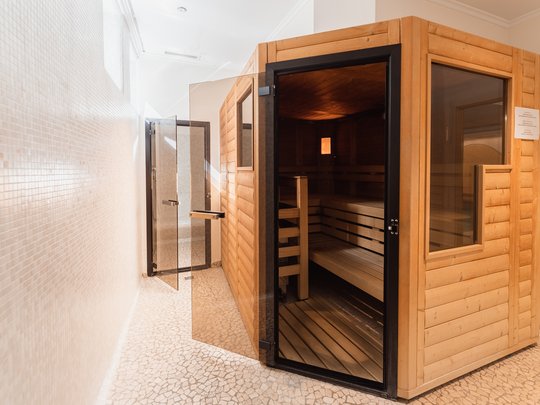 Hotel a Santa Cristina in Val Gardena con piscina: relax puro Sauna moderna con porta in vetro in una stanza ben illuminata