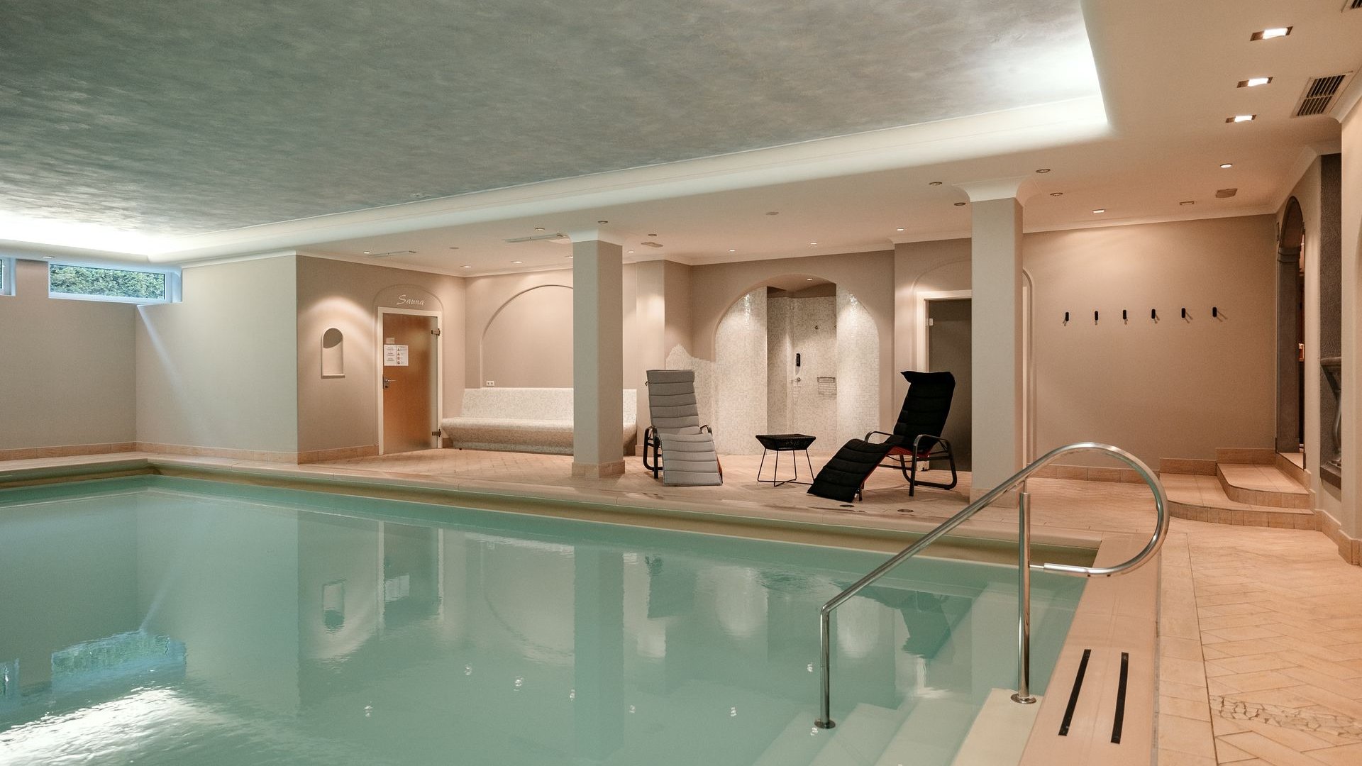 Hotel a Santa Cristina in Val Gardena con piscina: relax puro Interno con piscina, sedie a sdraio e porta della sauna