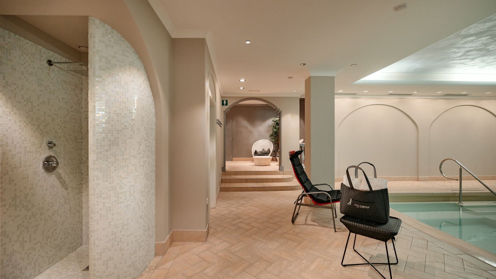 Hotel a Santa Cristina in Val Gardena con piscina: relax puro Area benessere moderna con doccia, sedia a sdraio e piscina piccola