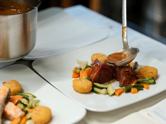 Il nostro hotel a 3 stelle in Val Gardena e la sua cucina Salsa versata su carne arrosto con verdure e crocchette su piatto bianco