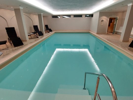 Deine Unterkunft in St. Christina im Grödnertal: Willkommen! Innenpool mit Liegestühlen und Sauna im Hintergrund