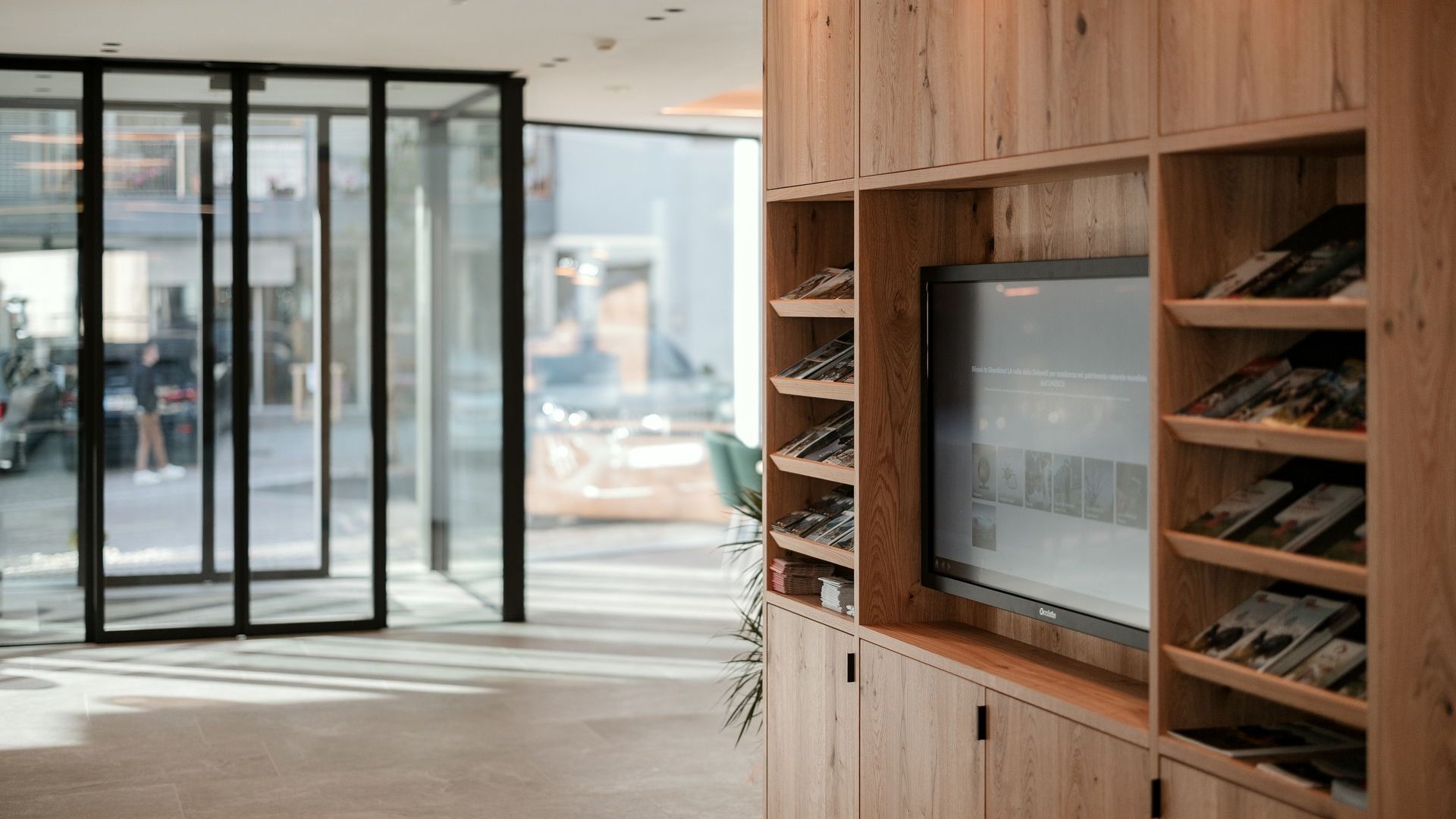Hotel a Santa Cristina in Val Gardena: your mountain escape Ingresso moderno con scaffale in legno e porta a vetri verso la strada