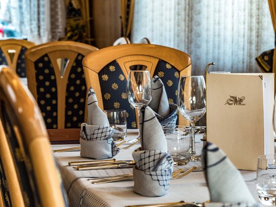 Il nostro hotel a 3 stelle in Val Gardena e la sua cucina Tavolo elegante apparecchiato con tovaglioli piegati e bicchieri in un ristorante