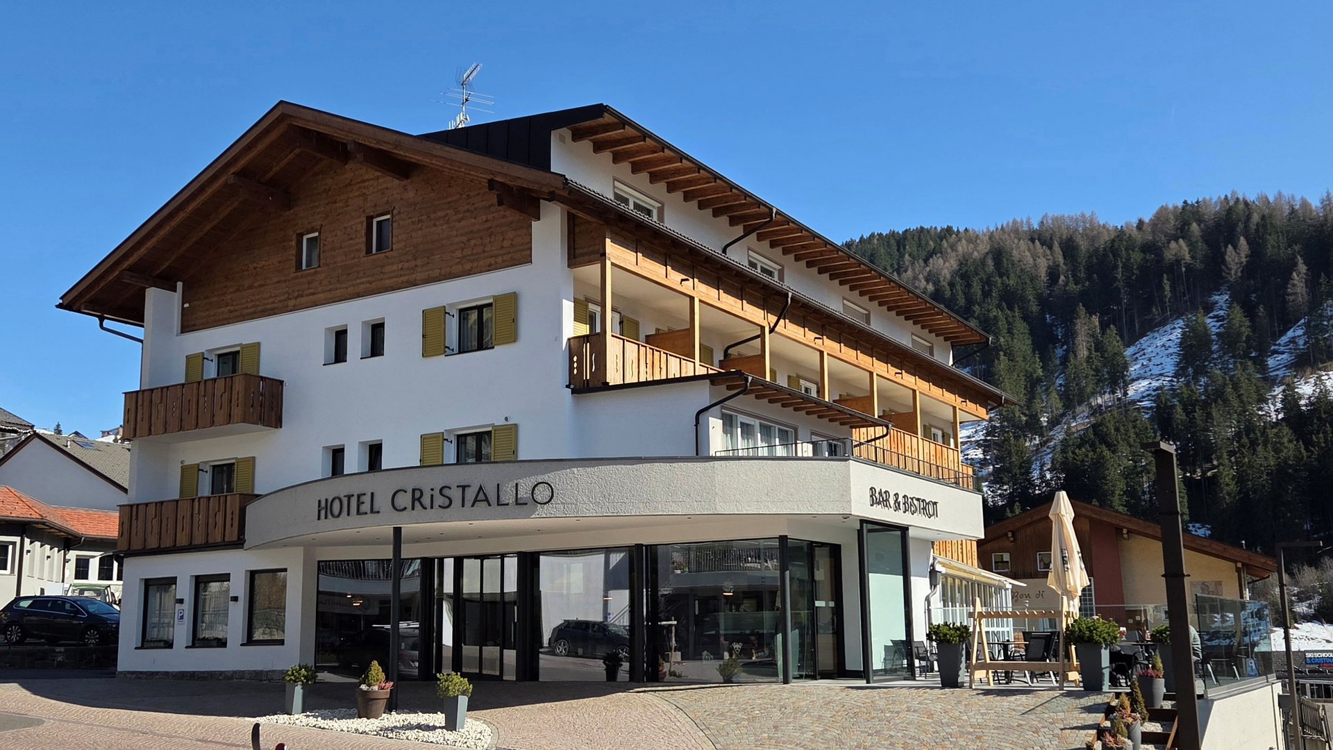 Deine Unterkunft in St. Christina im Grödnertal: Willkommen! Hotel Cristallo mit Bar und Bistrot in bergiger Winterlandschaft