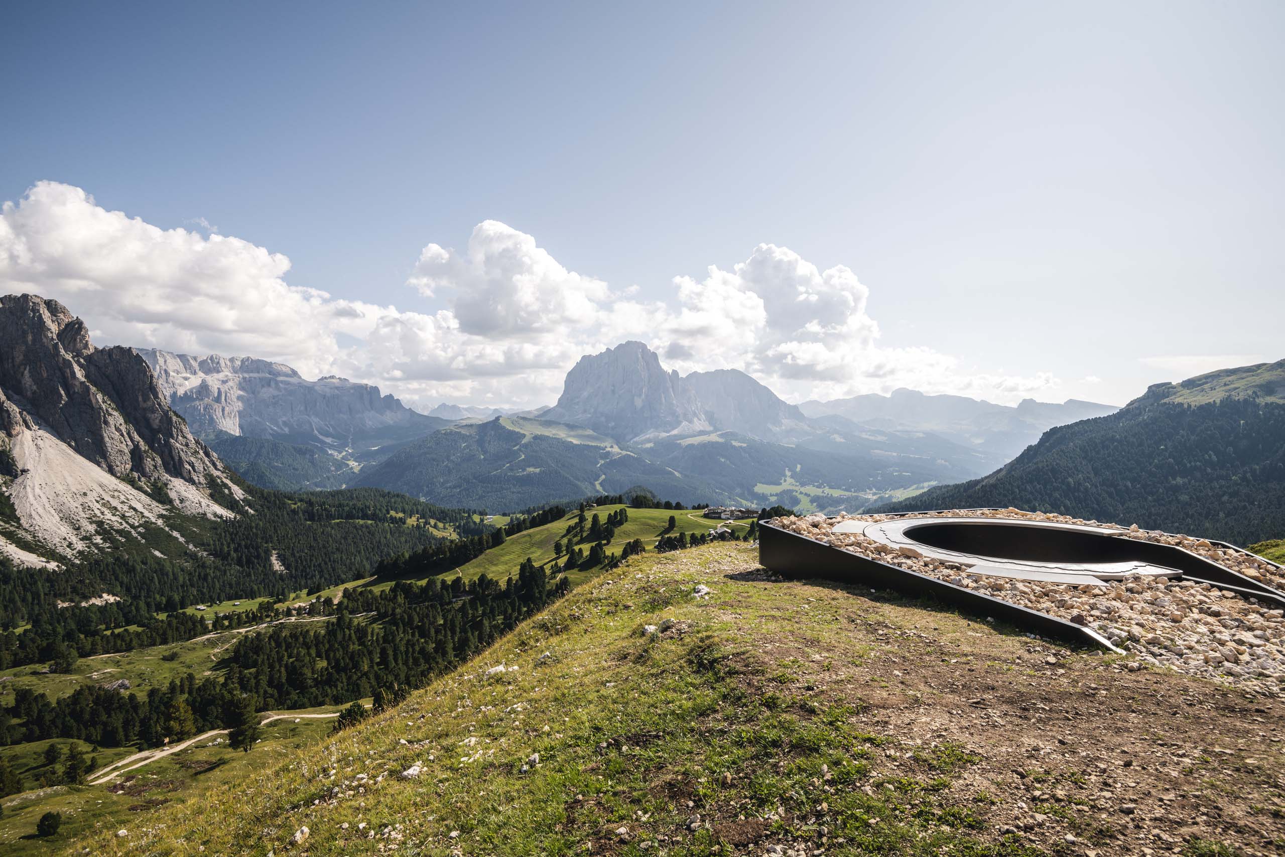 Hotel a Santa Cristina in Val Gardena: your mountain escape Paesaggio montano con rocce, prati e nuvole nel cielo